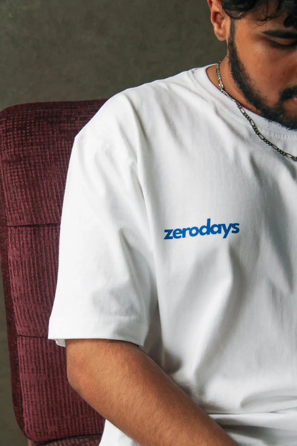 A closeup of the ‘Phoenix White Tee’ worn by one of the co-owners from Collection Zero focusing on the Zerodays branding on the front of the tee shirt.