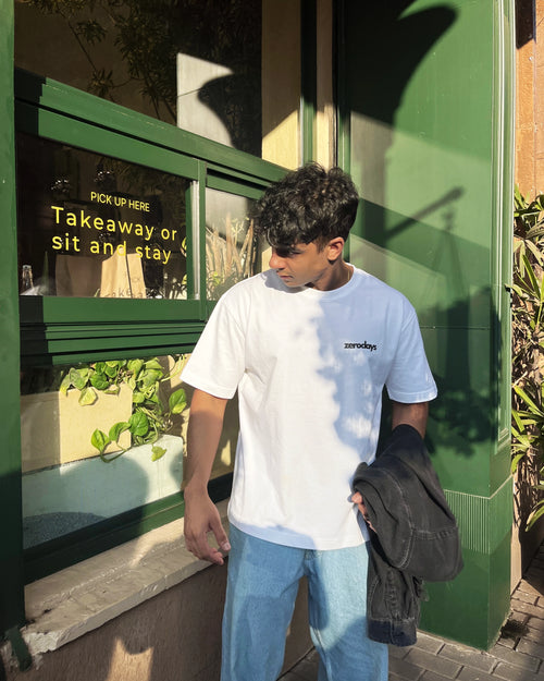 A stylised image of the White Zerodays Basic tee against an aesthetic background worn by the Co-founder of Zerodays 