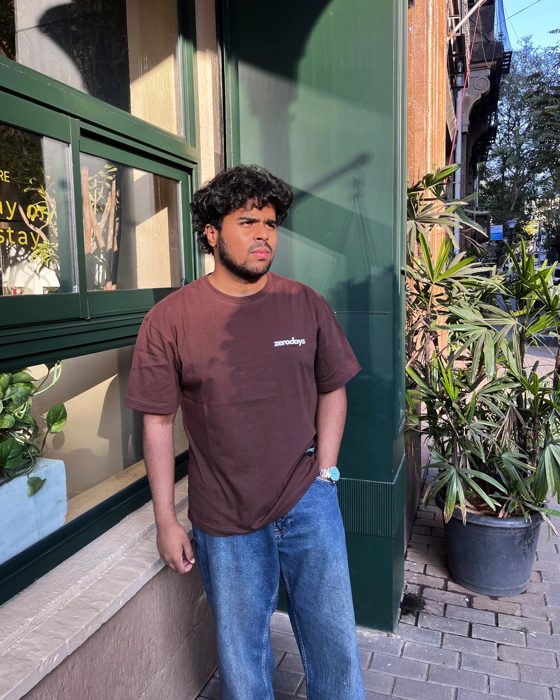 A stylised brown basic Zerodays image of the Zerodays basics worn by the Co-founder of Zerodays against an aesthetic background. 